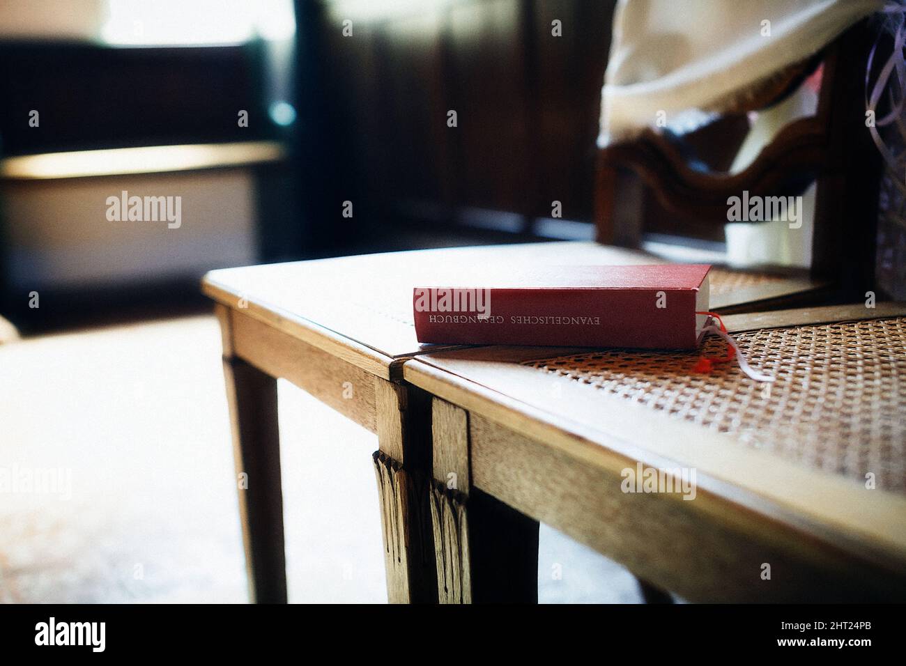 Nahaufnahme einer evangelikalen bibel auf Deutsch auf dem Stuhl mit einem verschwommenen Backgruond Stockfoto