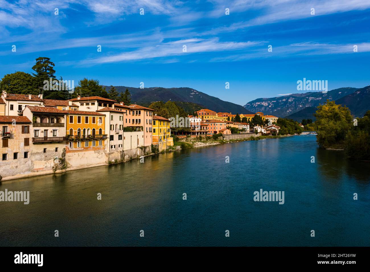 Fassaden mittelalterlicher Häuser von Bassano del Grappa, gelegen am Fluss Brenta, Ausläufern des Monte Grappa in der Ferne. Stockfoto