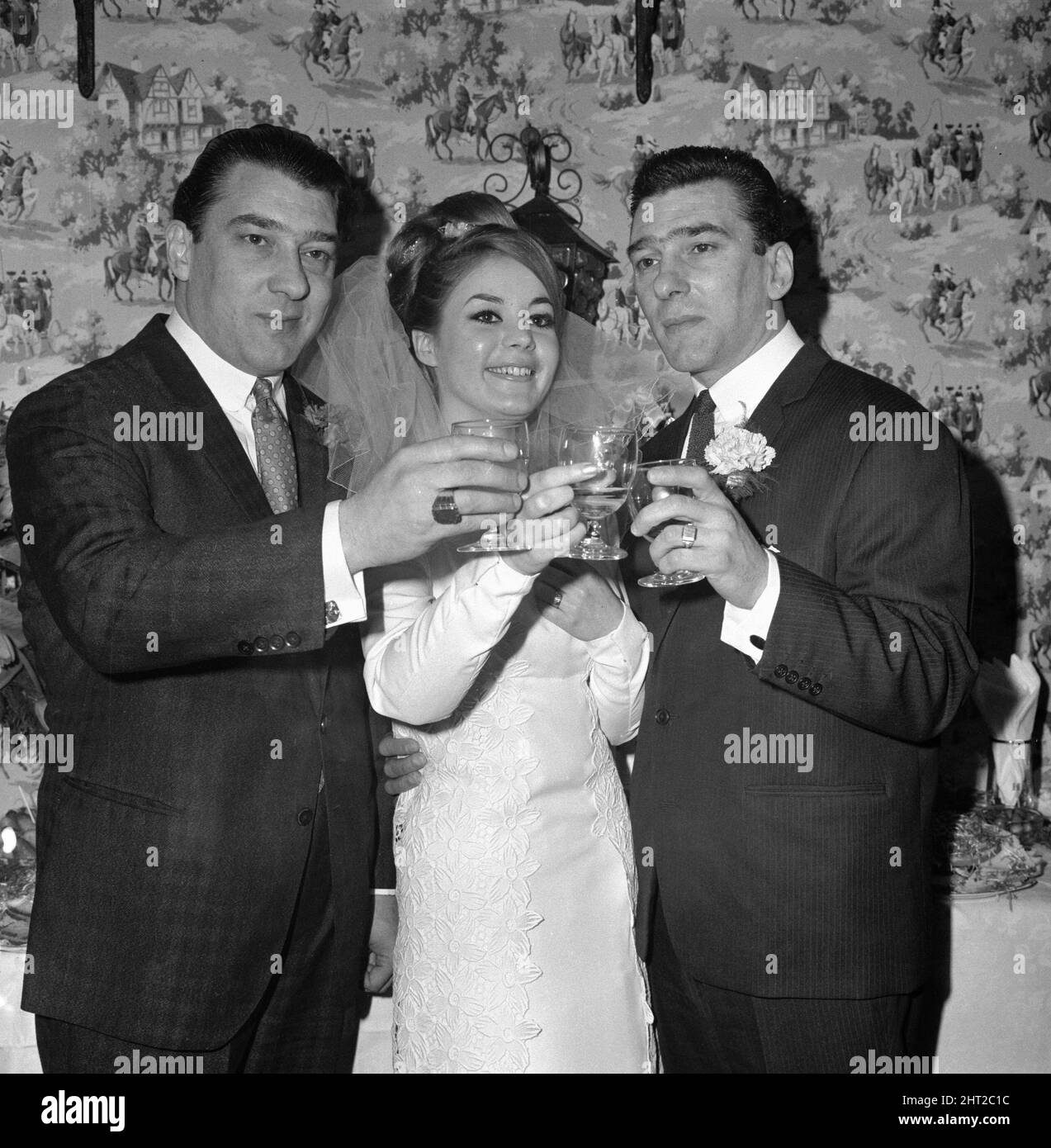 Hochzeit von Reggie Kray mit Francis Shea, Reggie Kray (rechts) und Ronnie Kray stoßen auf die Braut an, bei der Begrüßung, London, 19.. April 1965. Stockfoto