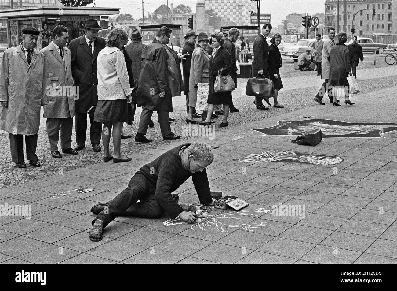 Passanten halten an und bewundern das Werk eines Straßenkünstlers, der die Gehwege von Rankestrafze und Kurfürstendamm als Leinwand verwendet. Ca. 1965 Stockfoto