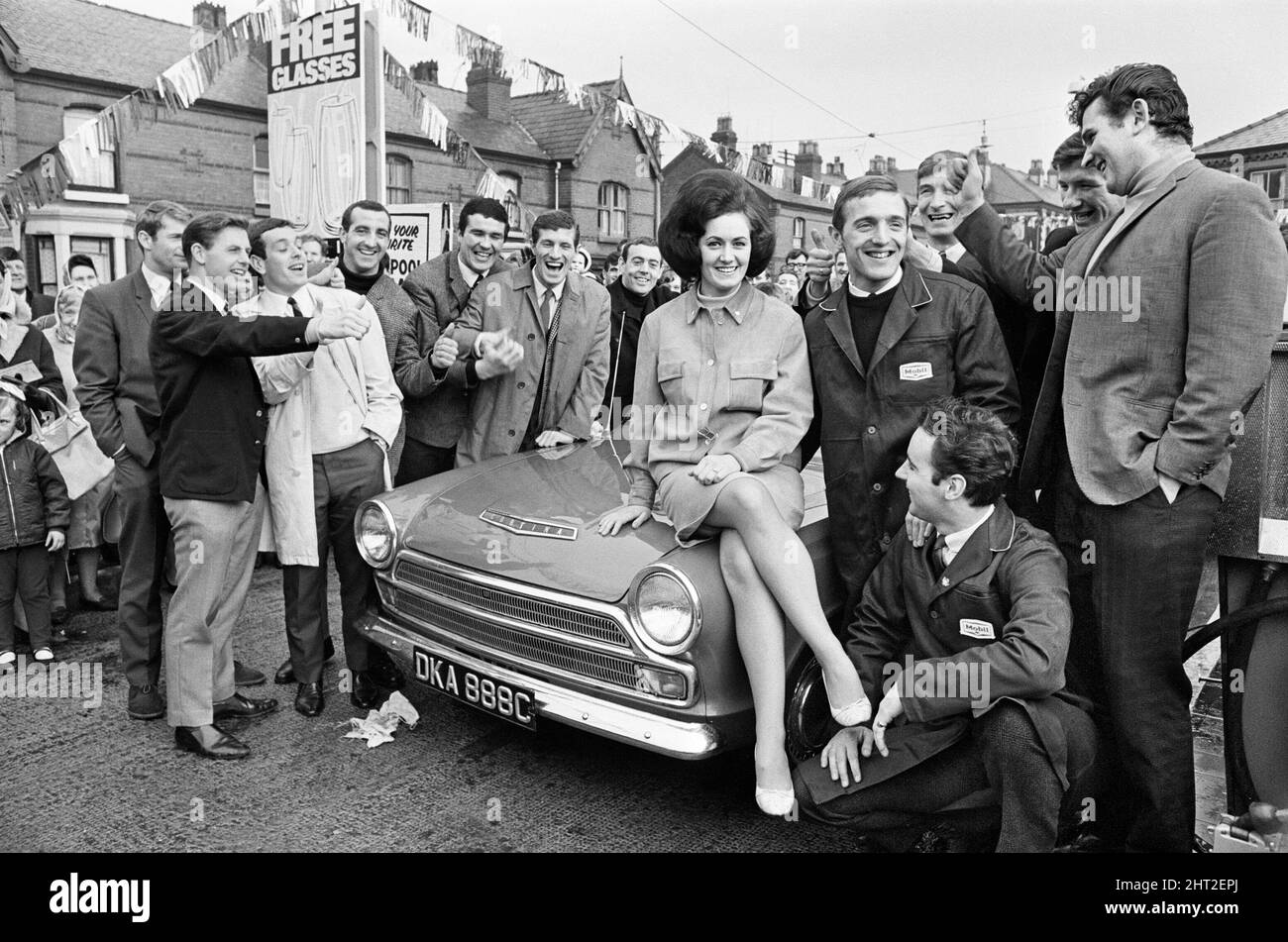 Liverpool Football Peter Thompson eröffnet eine neue Garage nur 100 Meter vom berühmten Anfield kop entfernt. Einige der riesigen Spieler, darunter Liverpool-Spieler von links nach rechts: Ron Yeats, Willie Stevenson, Ian St John, Peter Thompson und Geoff Strong mit Thompsons Verlobter Barbara Ponting, die auf der Motorhaube sitzt. 14.. März 1966. Stockfoto