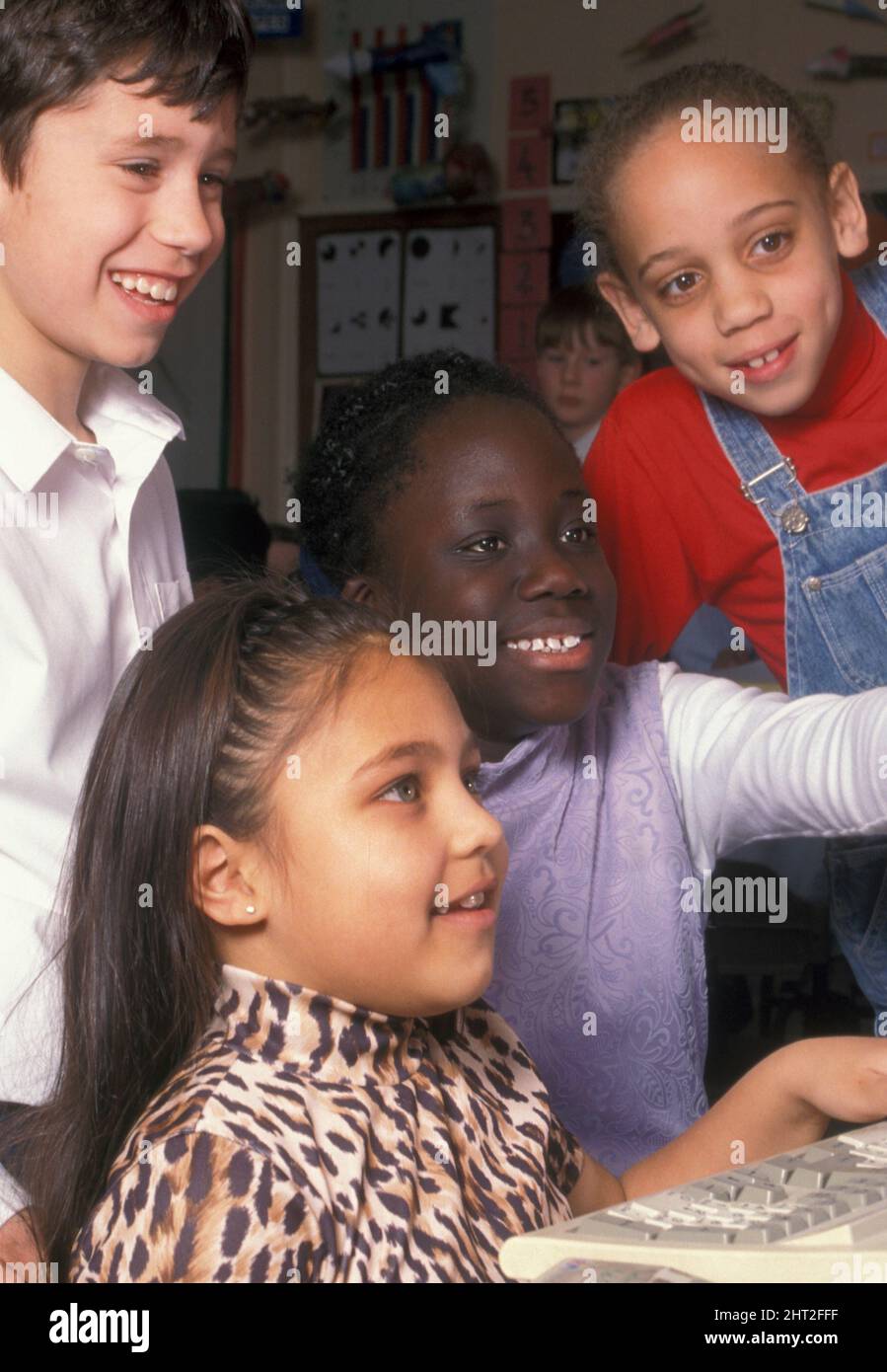 Multikulturelle Gruppe von Kindern in der Junior-Schule am Computer Stockfoto