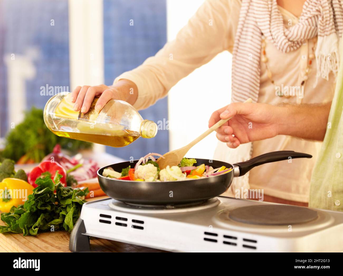 Benötigt mehr Öl. Zugeschnittenes Bild eines Paares, das in der Küche das Abendessen zubereitet. Stockfoto