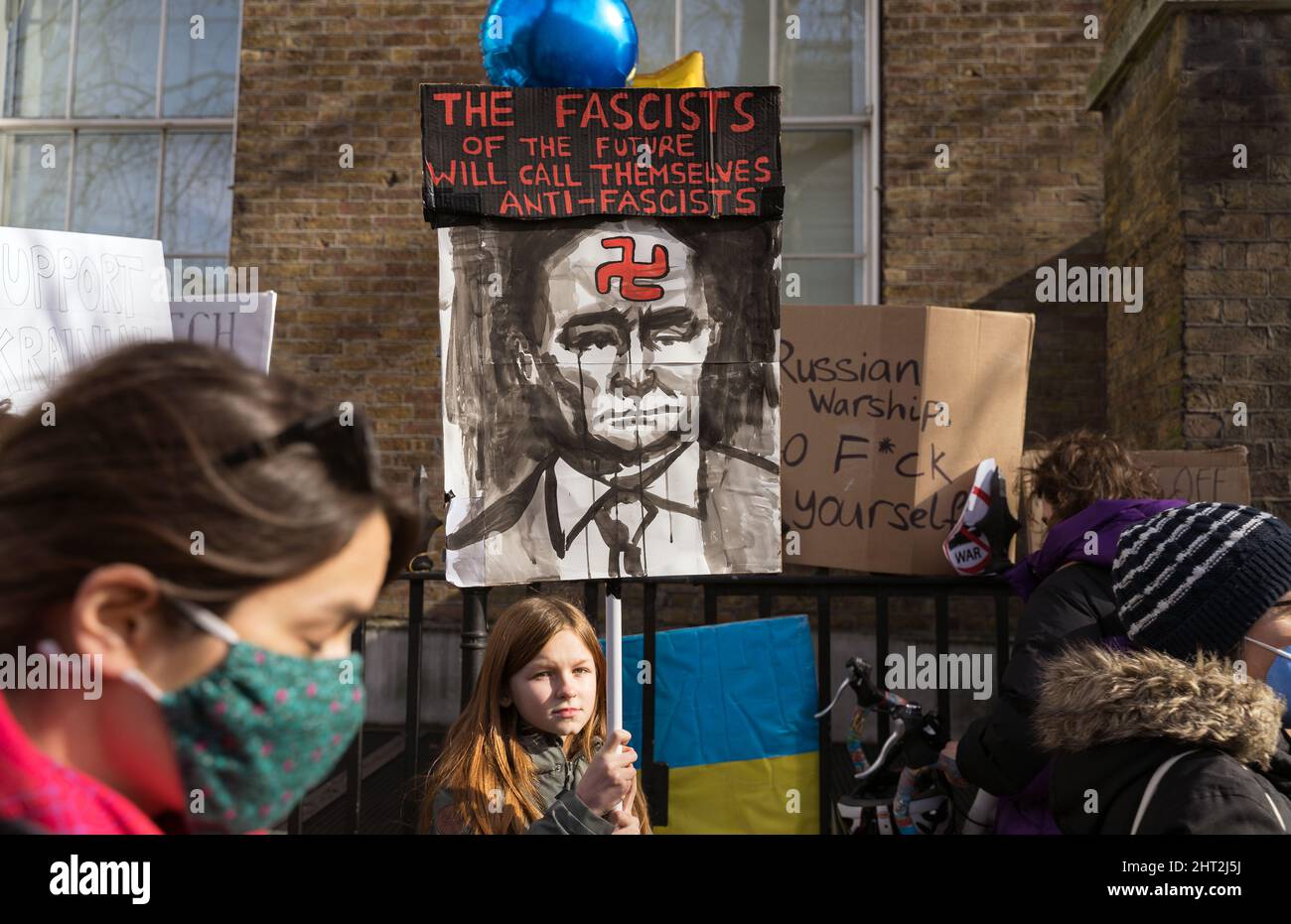 Protest gegen die russische Invasion der Ukraine vor der Downing Street. Mädchen mit einem Protestschild von Wladimir Putin. Konzentrieren Sie sich auf Zeichen und Mädchen Stockfoto