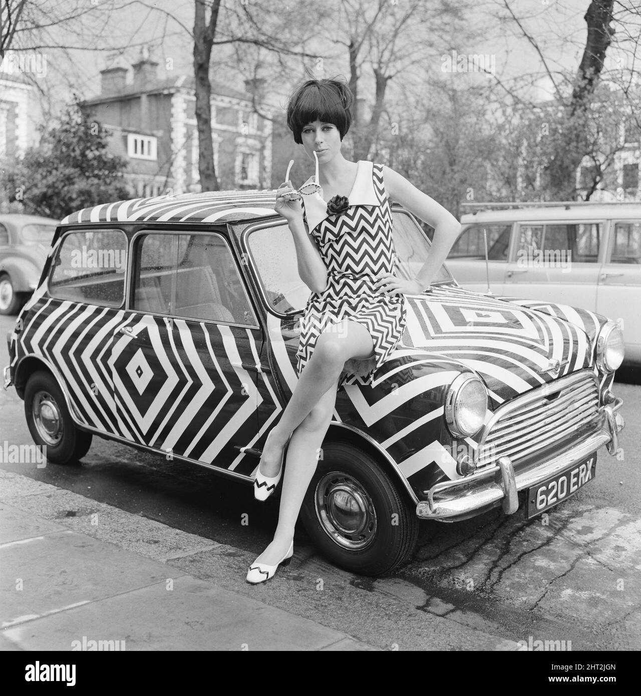 Hier ist es! Das Auto für das Mädchen Op Art (optisches Kunstmädchen), das alle ihre Accessoires passend mag, abgebildet am 24.. März 1966. Die Kunst wurde von der Amateurkünstlerin Danae Brook entworfen und angewendet, und das Auto steht in Thames Ditton, Surrey, zum Verkauf und kostet 385 £. Aber das beinhaltet nicht die Kosten für das Kleid, entworfen von Shubelle & das kostet 79 Schilling. Stockfoto