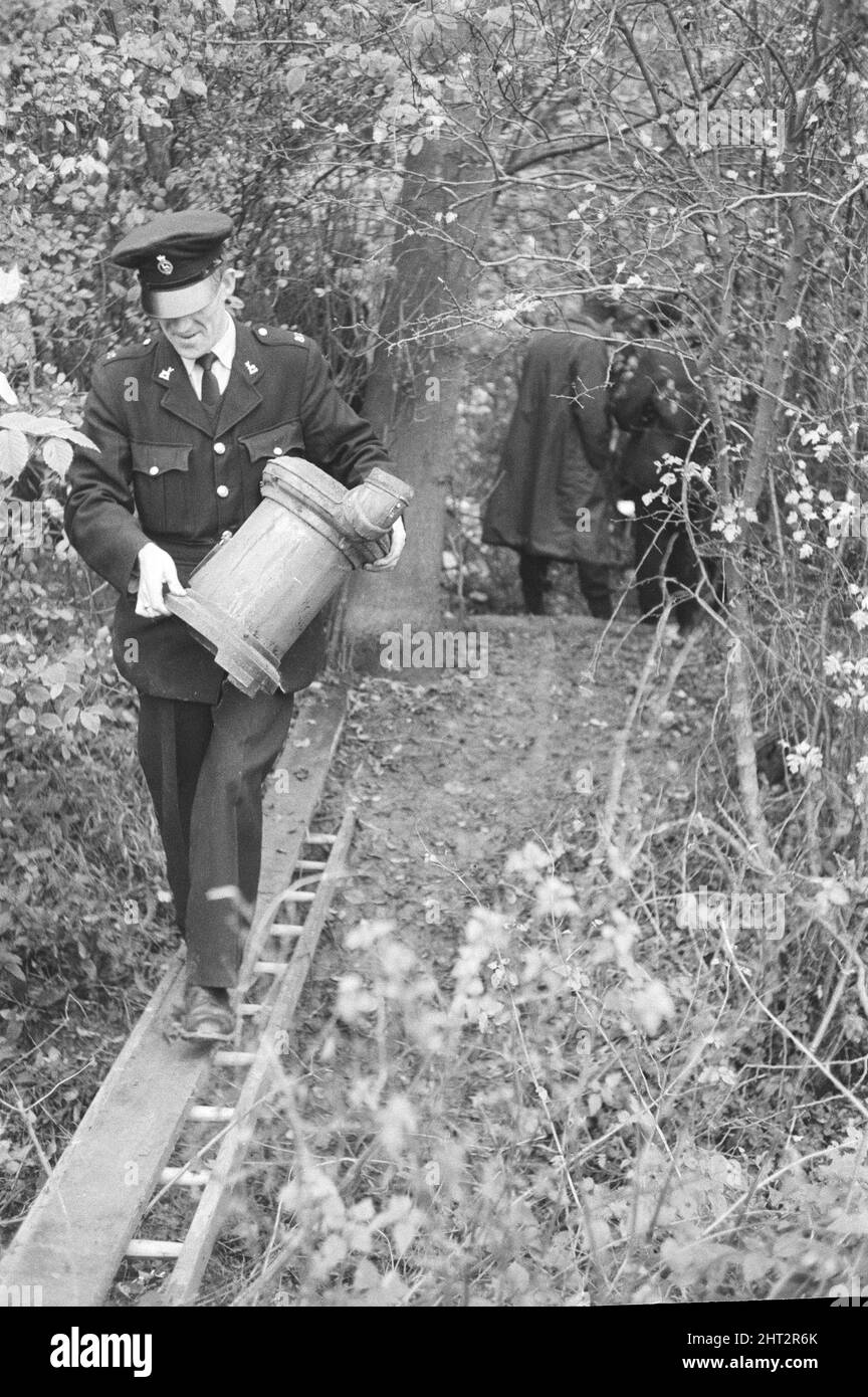 Harry Roberts wollte im Zusammenhang mit der Erschießung von drei Londoner Polizisten wurde heute in einem Wald bei Bishops Stortford in Herts wieder aufgenommen. Roberts, der seit mehr als drei Monaten gesucht wird, gab ohne Probleme der Polizei sgt Peter Smith nach. In einem getarnten Zelt am Rande von Thorley Wood entdeckte die Polizei eines der geschickt ausgeklügeltesten Verstecke, die je bekannt waren, wo Roberts in den letzten sechs Wochen gelebt hat. Das Zelt ist 5ft hoch an seinem höchsten Punkt und von einer Plastikfolie getarnt und enthielt eine Fülle von Lebensmitteln und Brennstoffen. Ein Camp-Bett und ein Aluminium-Stuhl wie wir Stockfoto