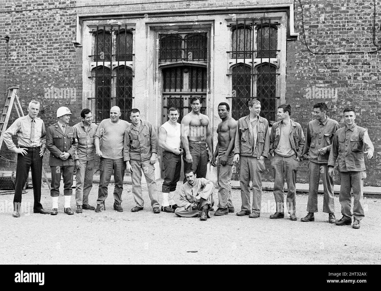 Dreharbeiten zu „The Dirty Dozen“ vor Ort am 13. Century Ashridge College, Hertfordshire, Großbritannien, Juni 1966. Von links nach rechts: Lee Marvin Richard Jaeckel Trini Lopez Telly Savalas Tom Busby Robert Phillips Clint Walker Al Mancini Jim Brown Donald Sutherland Stuart Cooper Ben Carruthers John Cassavetes Stockfoto