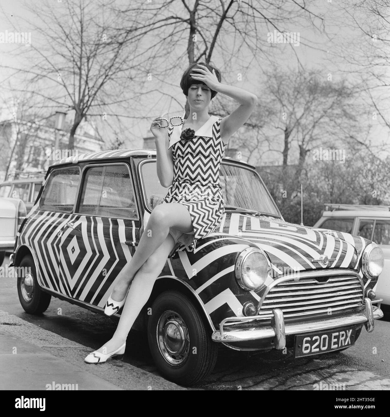 Hier ist es! Das Auto für das Mädchen Op Art (optisches Kunstmädchen), das alle ihre Accessoires passend mag, abgebildet am 24.. März 1966. Die Kunst wurde von der Amateurkünstlerin Danae Brook entworfen und angewendet, und das Auto steht in Thames Ditton, Surrey, zum Verkauf und kostet 385 £. Aber das beinhaltet nicht die Kosten für das Kleid, entworfen von Shubelle & das kostet 79 Schilling. Stockfoto
