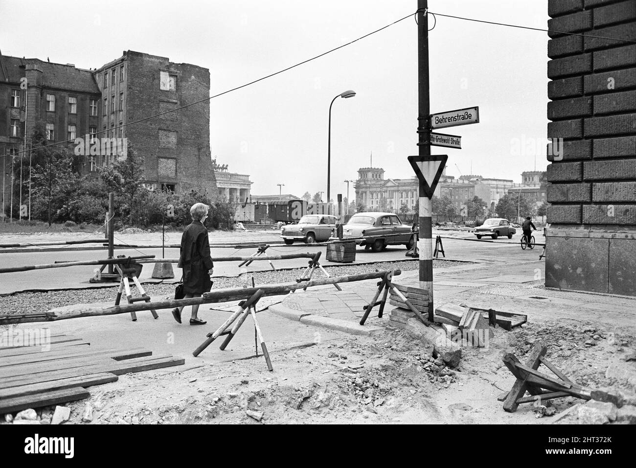 Szenen in Ost-Berlin, vier Jahre nach Beginn der Arbeiten am Bau der Berliner Mauer, die Ost und West trennt. Eine Frau, die die Otto Grotewohl Straße (kürzlich von der Wilhelmstraße umbenannt, nachdem sie von der Berliner Mauer in die Hälfte geschnitten wurde) in Richtung Kreuzung mit der Behrenstraße geht. 26. Mai 1965. Stockfoto