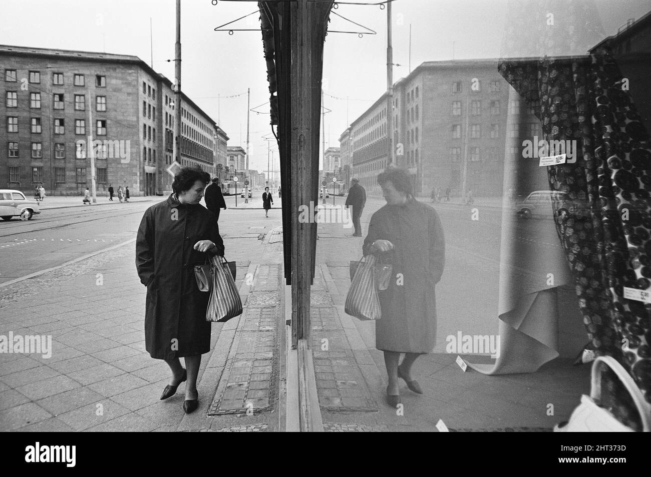 Szenen in Ost-Berlin, vier Jahre nach Beginn der Arbeiten am Bau der Berliner Mauer, die Ost und West trennt. Ein Ost-Berliner Schaufensterbummel auf einer der Hauptstraßen der Stadt. 26. Mai 1965. Stockfoto