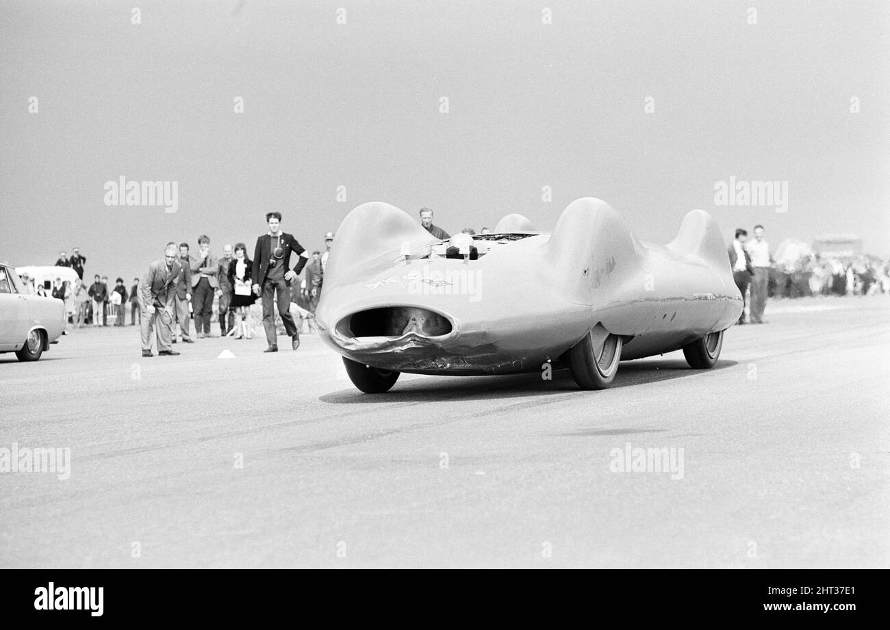 Proteus Bluebird, das Auto, mit dem Donald Campbell den Weltrekord im Automobilbau gebrochen hat, hat nun seinen letzten Lauf mit 5 mph auf der RAF Station, Debden, Essex, 19.. Juni 1966. Campbell sollte dort bei einer Gala einen Demonstrationslauf geben, Doch 5 Tage zuvor wurde das Auto schwer beschädigt, als es mit dem Rennfahrer Peter Bolton an der Steuerung durch einen Holzzaun und eine Hecke mit 100 km/h zerschmetterte, 10ft in der Luft über die Cambridge Chelsford Road segelte und schließlich 200 Meter lang über ein Feld drehte. Stockfoto