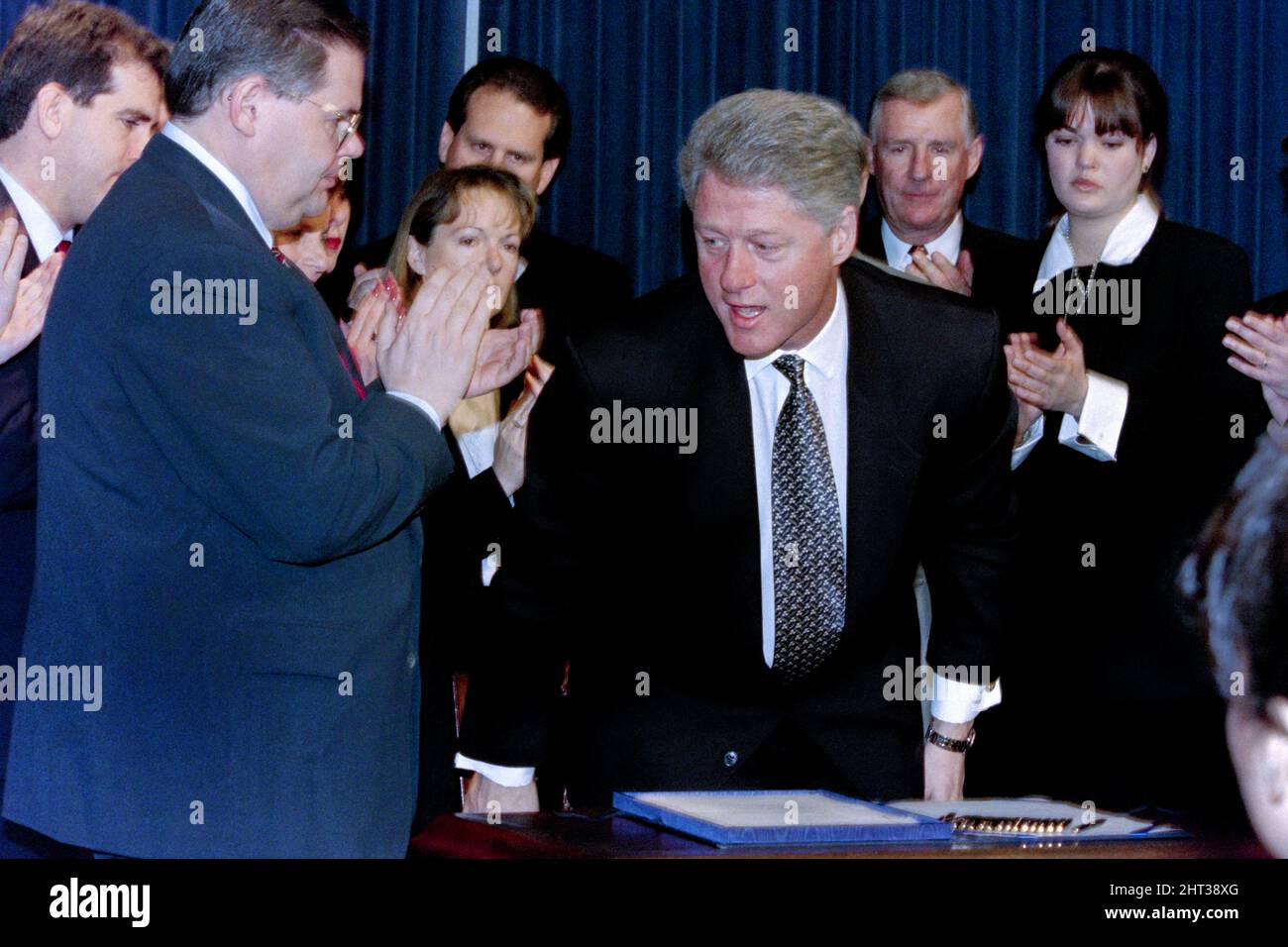 Washington, DC, USA. 12.. März 1996. Der Republikaner Robert Menendez (D-NJ) applaudiert, nachdem US-Präsident Bill Clinton den Helms-Burton-Gesetzentwurf zur Verschärfung des kubanischen Embargos im Gebäude des Alten Exekutivbüros des Weißen Hauses am 12. März 1996 in Washington unterzeichnet hat, D.C. um den Präsidenten herum sind Familienmitglieder von Piloten der Brüder der Rettung, die getötet wurden, als ihre Flugzeuge von kubanischen Kampfflugzeugen abgeschossen wurden. Stockfoto