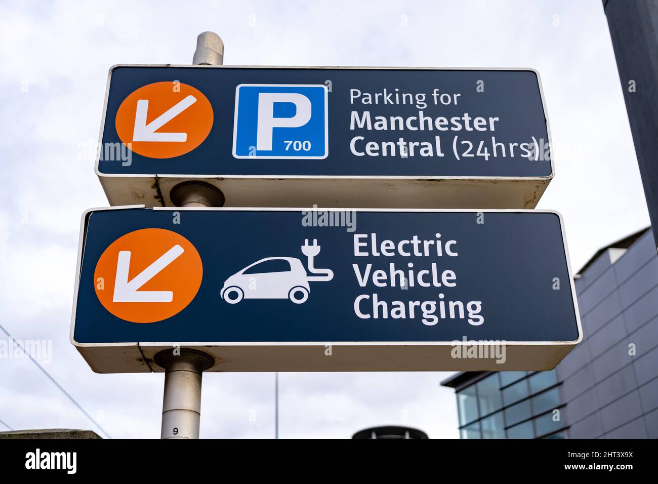 Manchester UK Richtungsschild für Parkplatz und Ladestation für Elektrofahrzeuge mit Logos Stockfoto