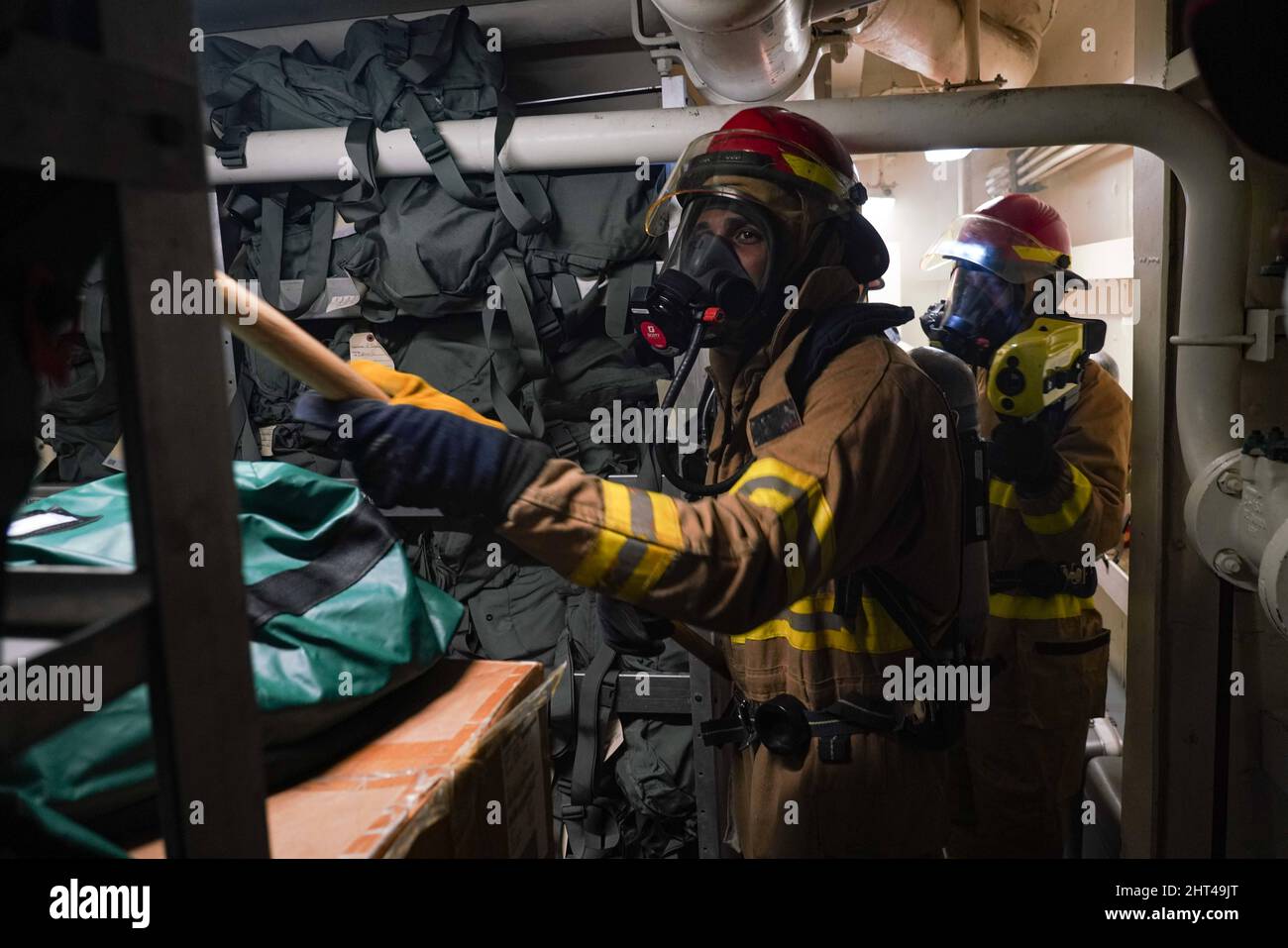 PHILIPPINISCHES MEER (Feb 1, 2022) Fireman Branden Romero, Center, ein gebürtiger aus Brooklyn, New York, betreibt einen Rechen auf der Suche nach Hotspots, als Damage Controlman 3. Class Evan Roberts, rechts, aus Henry County, Georgia, während einer Schadenskontrollübung an Bord des Amphibiendocks USS Pearl Harbor der Harpers Ferry-Klasse eine Wärmebildkamera betreibt (LSD 52), in der philippinischen See, 1. Februar 2022. Marine Exercise Philippines (MAREX PH) zeigt das Engagement der USA für die Region und unsere langjährigen Verbündeten im Vertrag. Wir streben danach, dauerhafte, für beide Seiten vorteilhafte Beziehungen aufzubauen und investieren in Schulungen, um eine Fre zu gewährleisten Stockfoto
