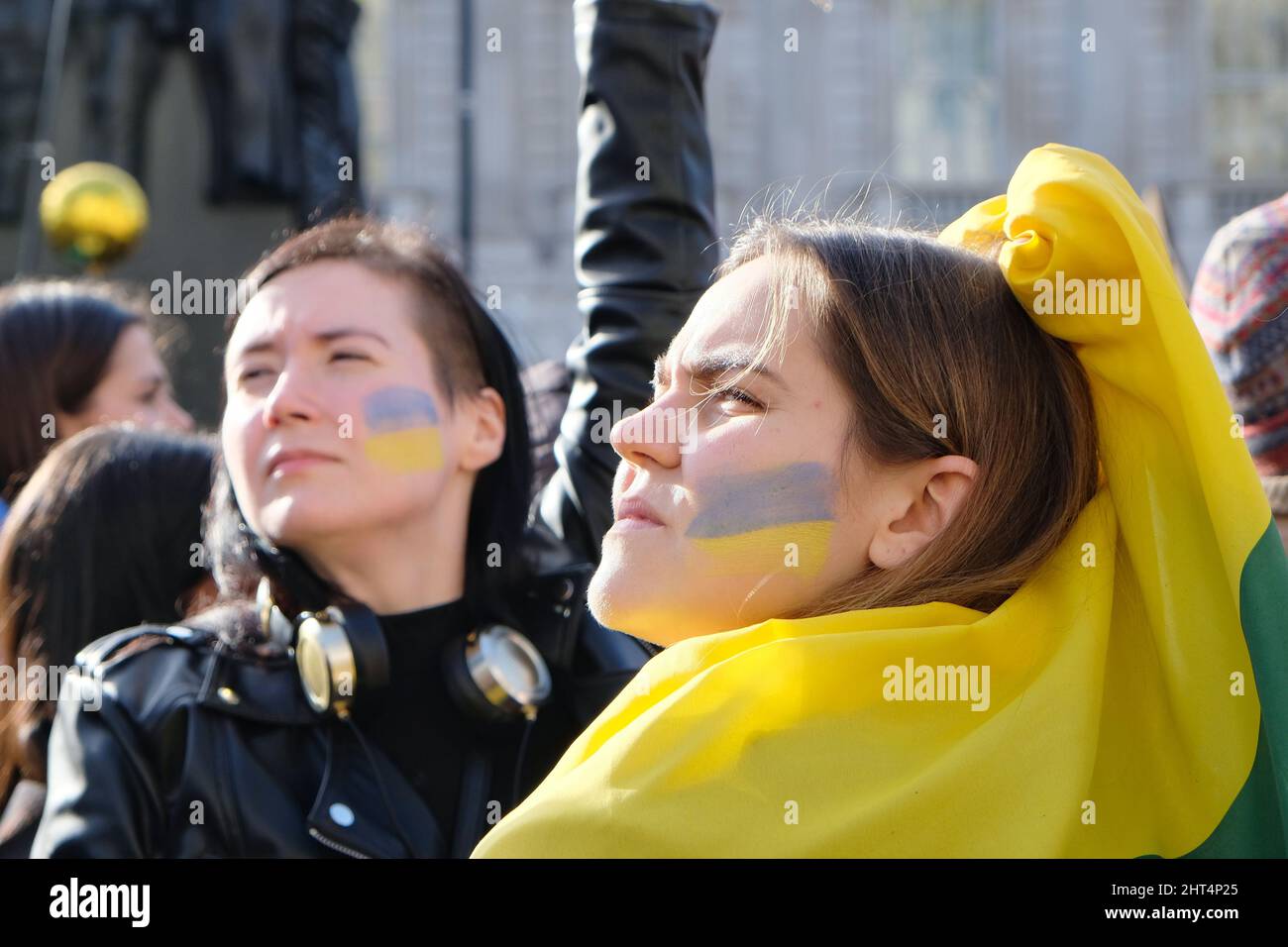 London, Großbritannien, 26.. Februar 2022, zwei Frauen mit ukrainischer Flagge auf ihren Wangen stehen mit Hunderten von anderen in Whitehall zusammen, um gegen die ukrainische Invasion zu demonstrieren und zu verstärkten Wirtschaftssanktionen zu rufen, wie zum Beispiel den Zugang zu dem Swift-Zahlungssystem, das den russischen Banken verhängt werden soll. Kredit: Elfte Stunde Fotografie/Alamy Live Nachrichten Stockfoto