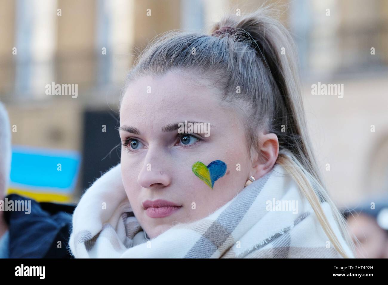 London, Großbritannien, 26.. Februar 2022, Eine Frau mit einem Herzen in ukrainischen Flaggen-Farben war eine von Hunderten, die in Whitehall zu einer Kundgebung und Demonstration gegen die ukrainische Invasion zusammengekommen waren und zu verstärkten Wirtschaftssanktionen aufriefen, wie zum Beispiel der Einschnitt des Zugangs zum Swift-Zahlungssystem für die russischen Banken. Kredit: Elfte Stunde Fotografie/Alamy Live Nachrichten Stockfoto