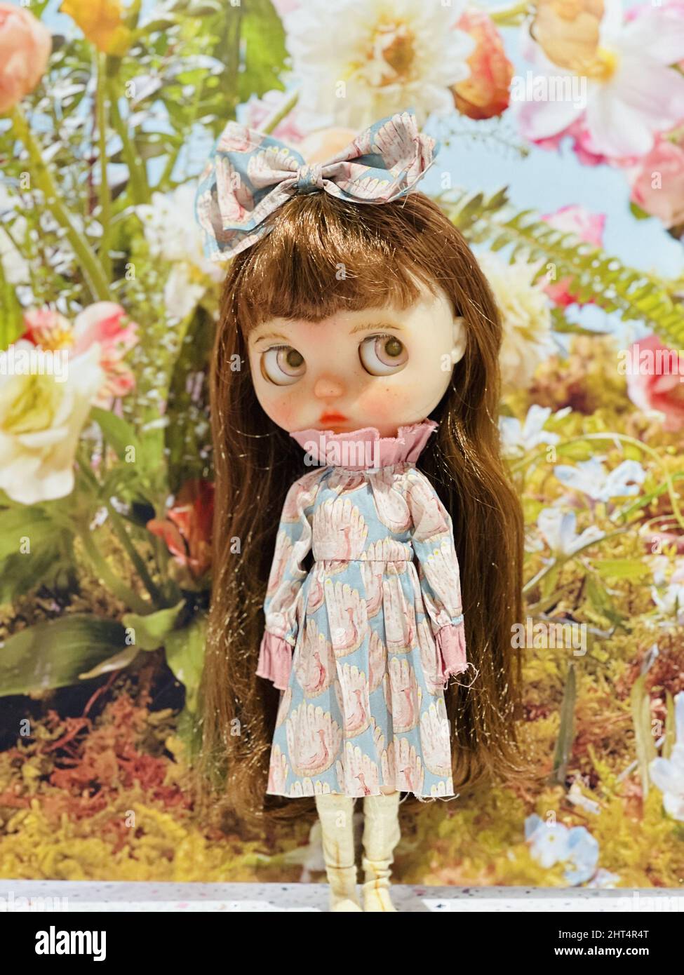 Nahaufnahme einer schönen Puppe mit Blumen im Hintergrund Stockfoto
