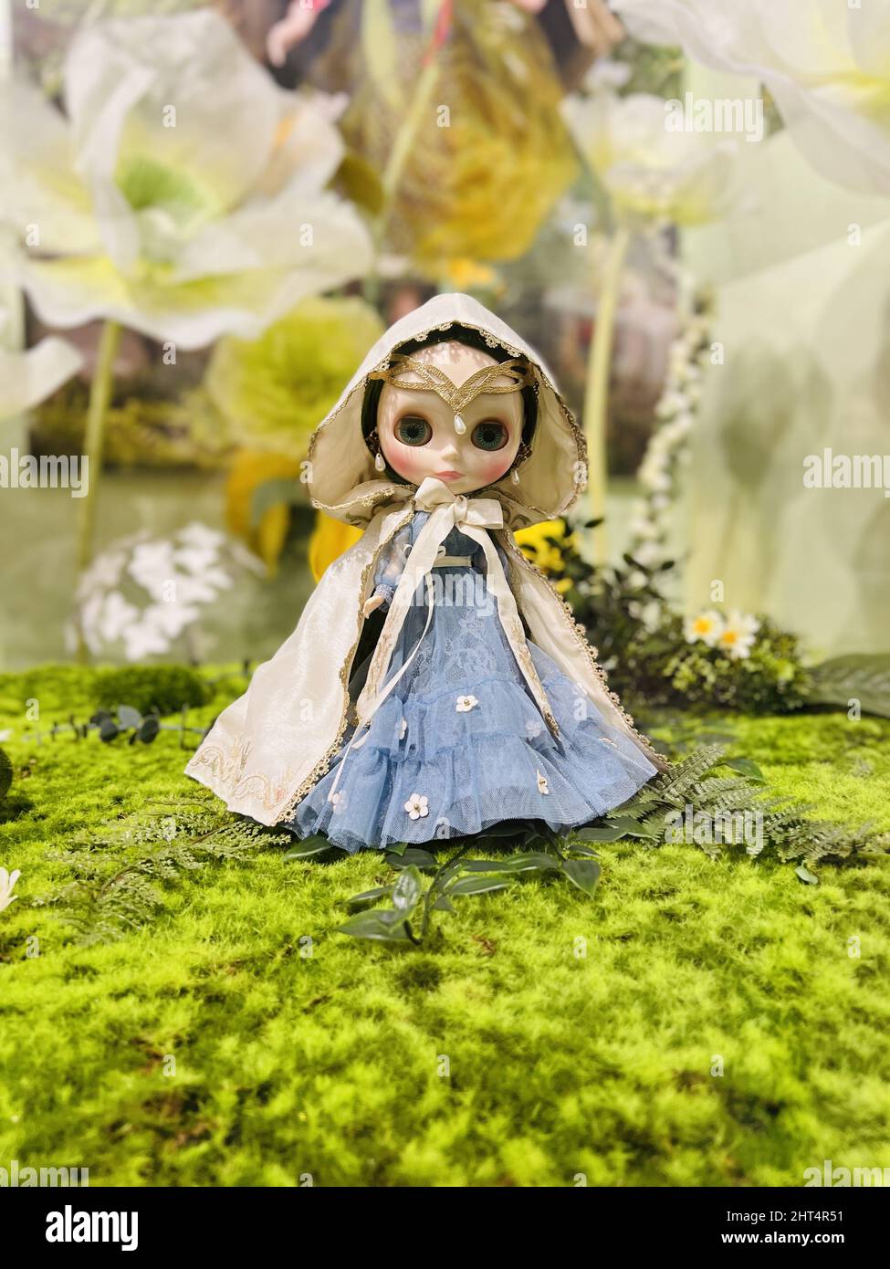 Nahaufnahme einer schönen Puppe mit Blumen im Hintergrund Stockfoto