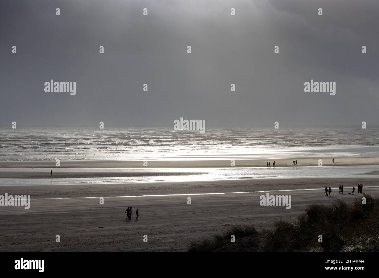 Landschaft des Camber Sands Beach unter dem Sonnenlicht und einem stürmischen Himmel in Rye, England Stockfoto