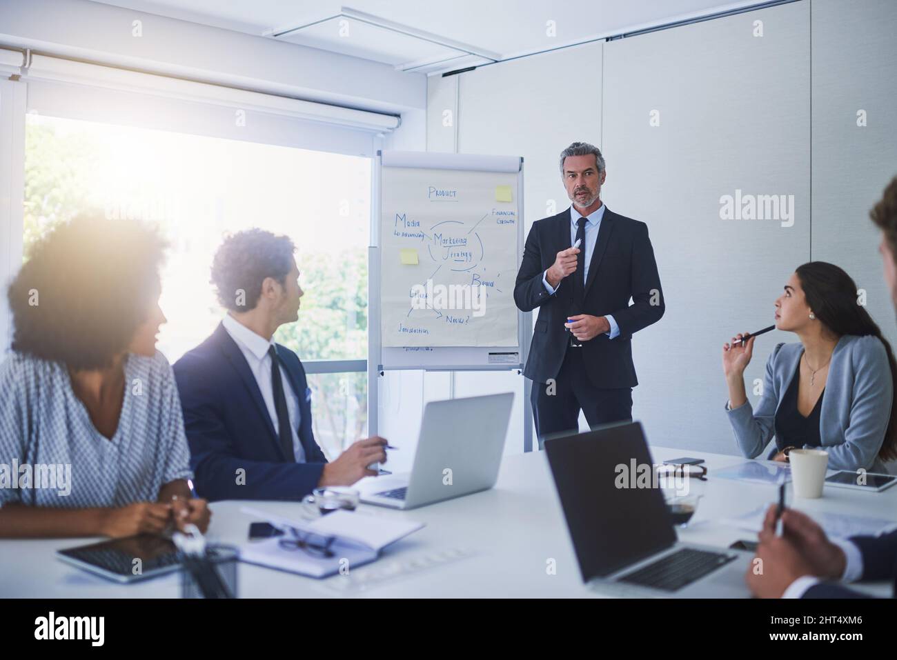 Sie scheitern nie daran, hart für den Erfolg zu planen. Aufnahme eines reifen Geschäftsmannes, der seine Kollegen in einem Büro vorstellte. Stockfoto