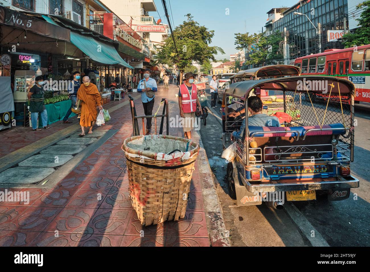 Straßenszene mit einem buddhistischen Mönch und Tuk-Tuks (Dreirad-Taxis) auf dem Pak Klong Talat (Markt), Bangkok, Thailand Stockfoto
