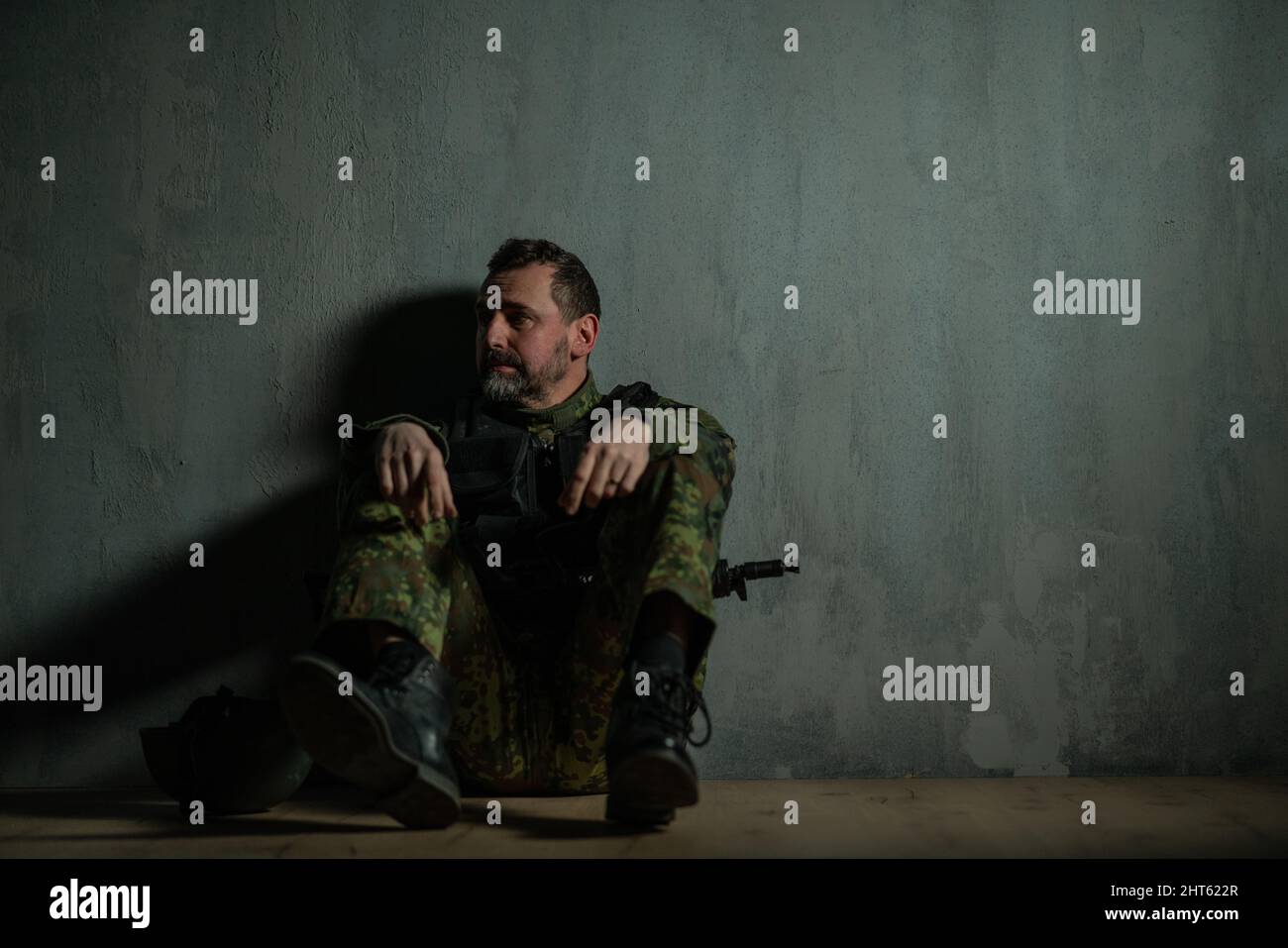Frustrierter Militärsoldat, der im Bootcamp sitzt Stockfoto