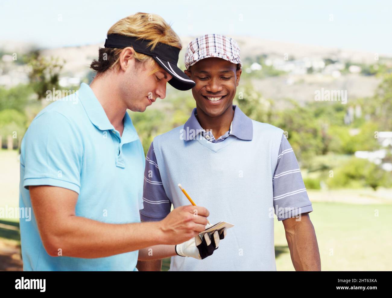 Scherz über die Scorecard. Aufnahme von zwei Freunden, die ihre Golf-Scorecard markieren und lachen. Stockfoto