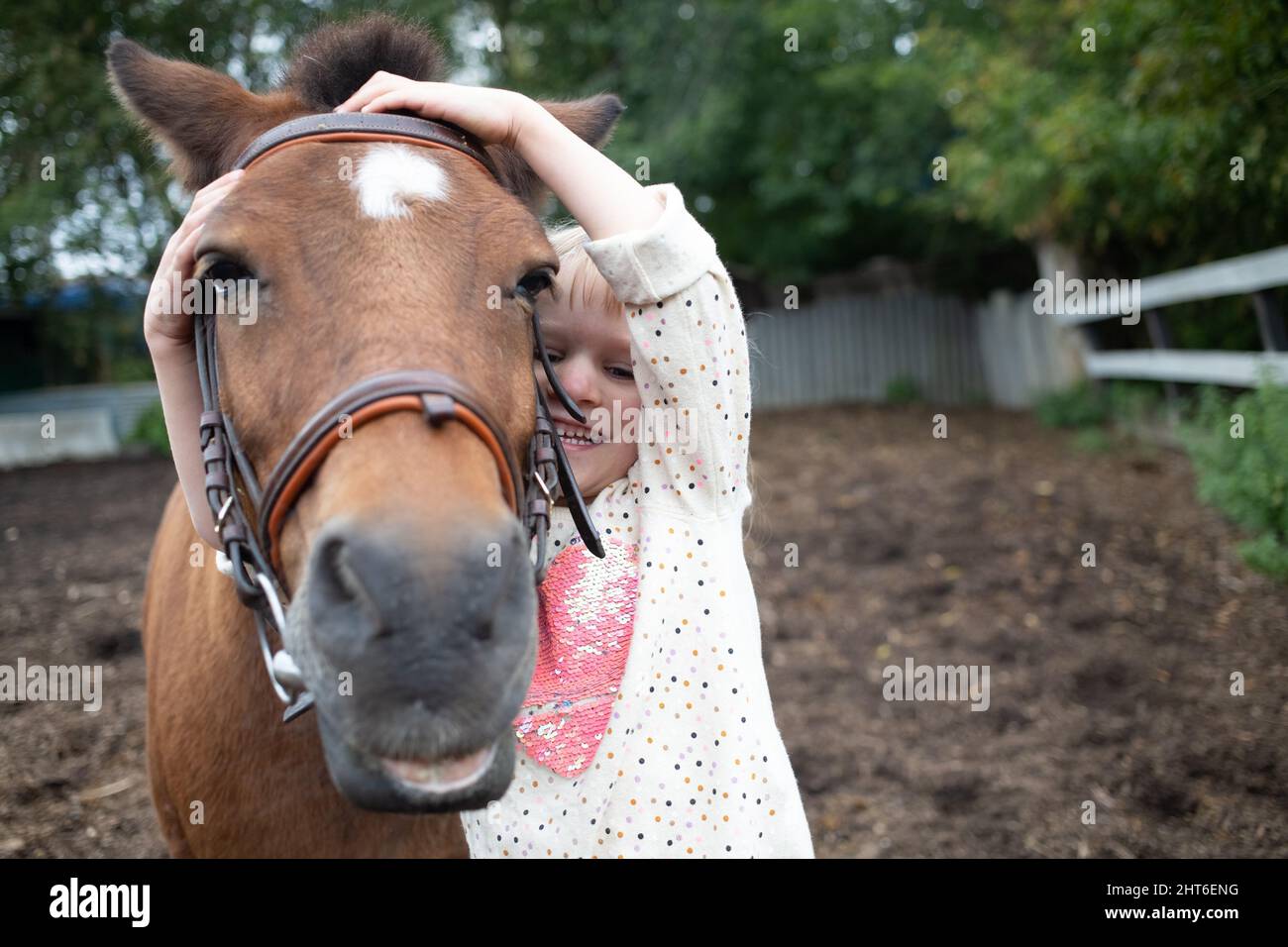 Mädchen umarmt Pony Pferd Schnauze auf Ranch Stockfoto