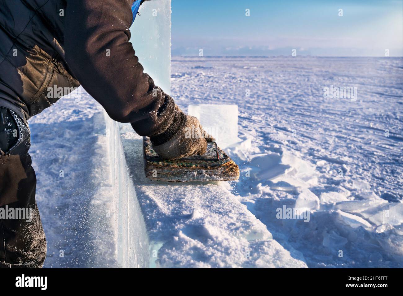 Bildhauer poliert Eis mit einem handgefertigten Werkzeug, um Eisskulpturen am Baikalsee zu machen. Stockfoto