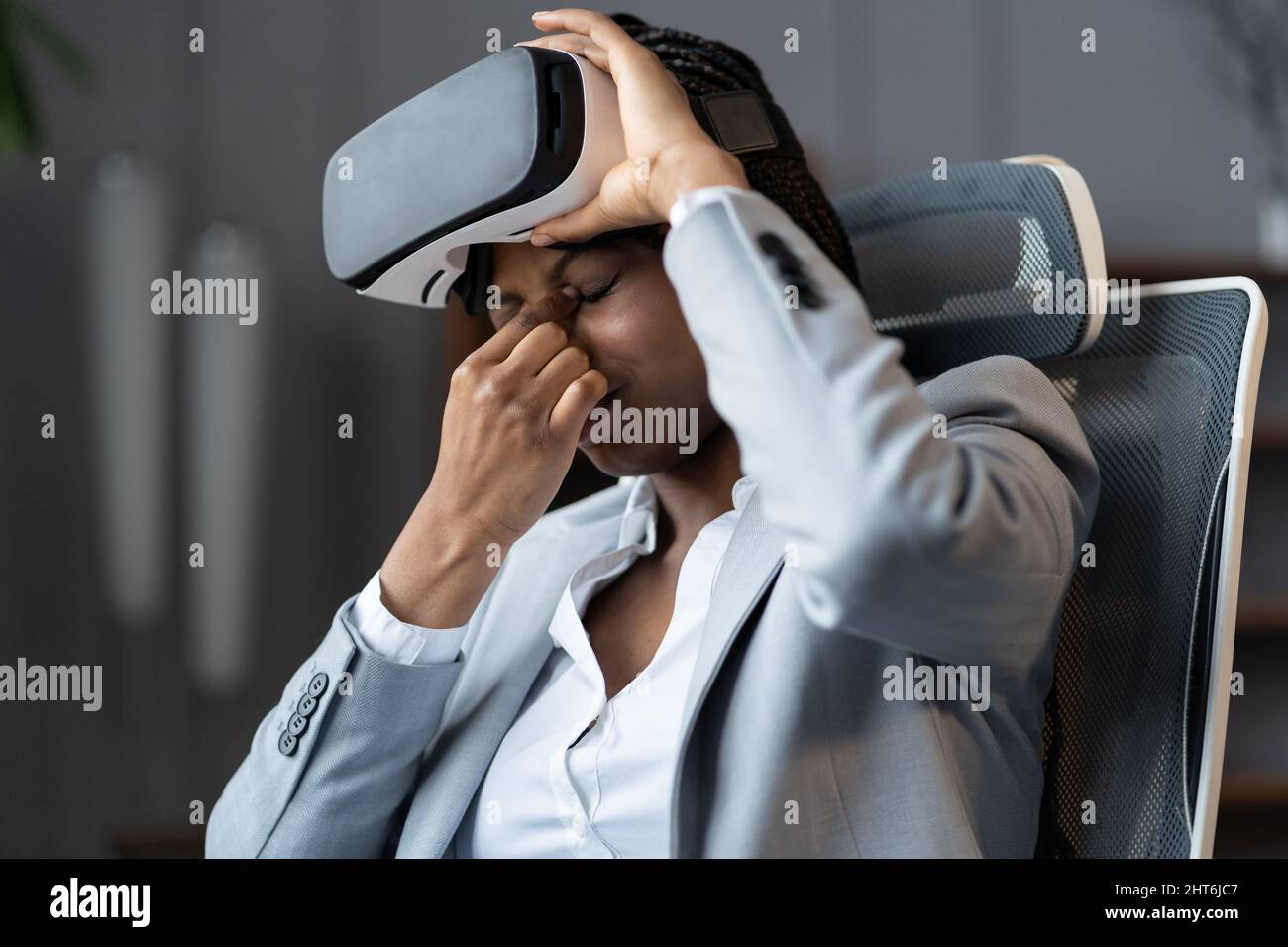 Ungesunde Geschäftsfrau leidet unter Augenbelastung Sie fühlen sich bei der Arbeit Kopfschmerzen durch eine Virtual-Reality-Brille Stockfoto
