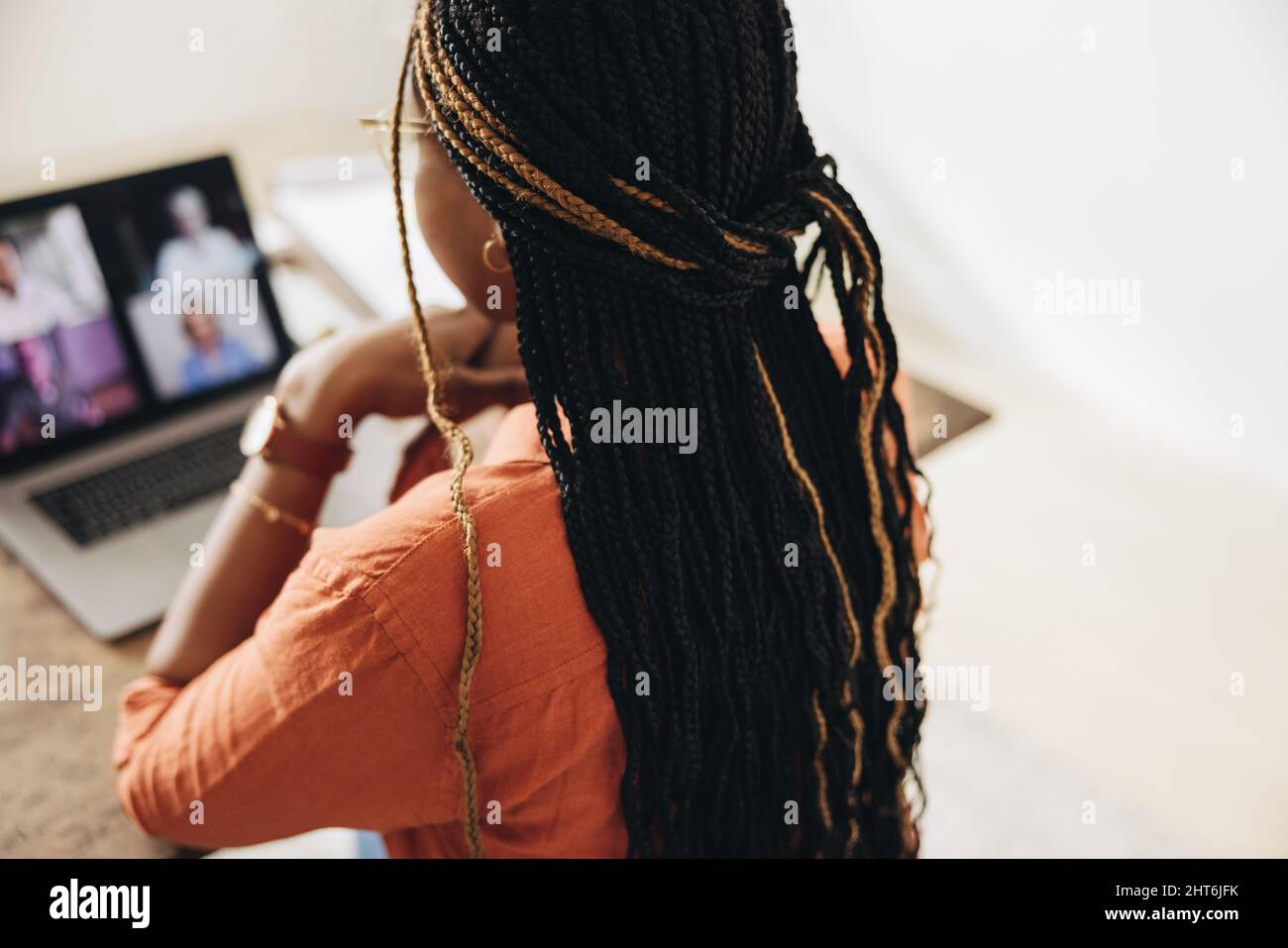 Kreative junge Frau, die an einem virtuellen Treffen mit ihren Kunden teilnimmt. Freiberufliche Mitarbeiterin, die einen Laptop für einen Videoanruf verwendet. Junge Grafikdesignerin sitzt ein Stockfoto