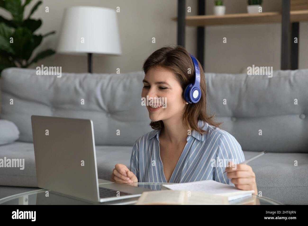 Glückliche schöne Frau beim Betrachten pädagogischer Vortrag auf dem Laptop. Stockfoto