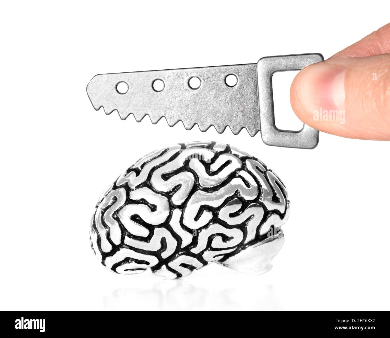 Sägen einer anatomischen Miniatur-Kopie eines menschlichen Gehirns mit einer kleinen Säge auf weißem Hintergrund. Beziehungsschwierigkeiten Konzept. Stockfoto
