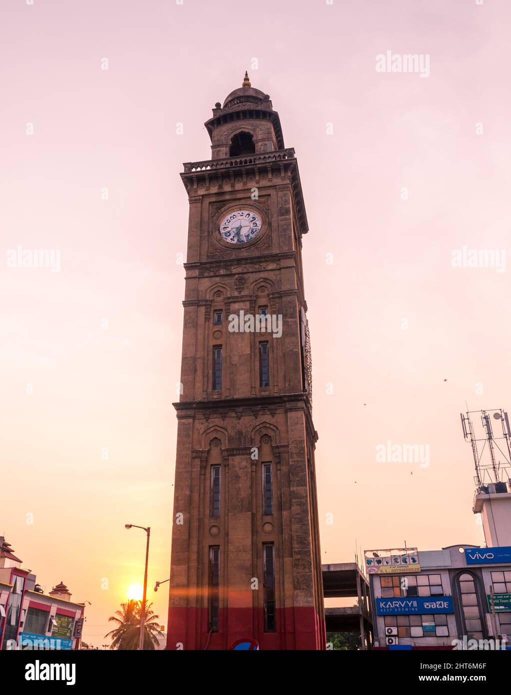 100 Jahre alter indosarakischer Uhrturm (bekannt als Dodda Gadiaya oder Silver Jubilee Clock Tower) mit Ziffern in Kannada-Sprache in Mysore, Karnataka, Stockfoto