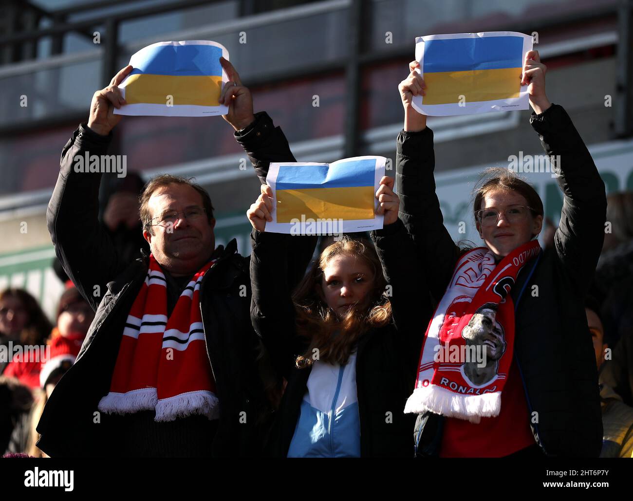 Fans von Manchester United halten Ausdrucke der Flagge der Ukraine hoch, um ihre Unterstützung nach der Invasion Russlands während des fünften Spielrunde des Vitality Women's FA Cup im Leigh Sports Village, Manchester, zu zeigen. Bilddatum: Sonntag, 27. Februar 2022. Stockfoto
