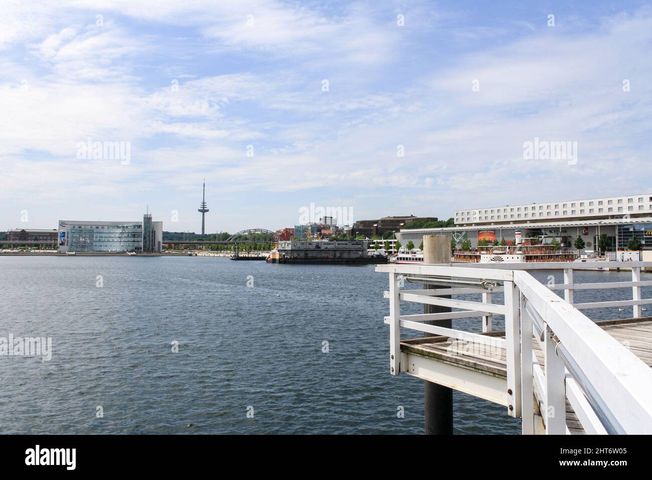 Landschaftsansicht der Kieler Stadt im Sommer mit Hörn Campus und Kieler Turm im Hintergrund am Hafen von Kiel. Wolken am blauen Himmel. Keine Personen. Stockfoto