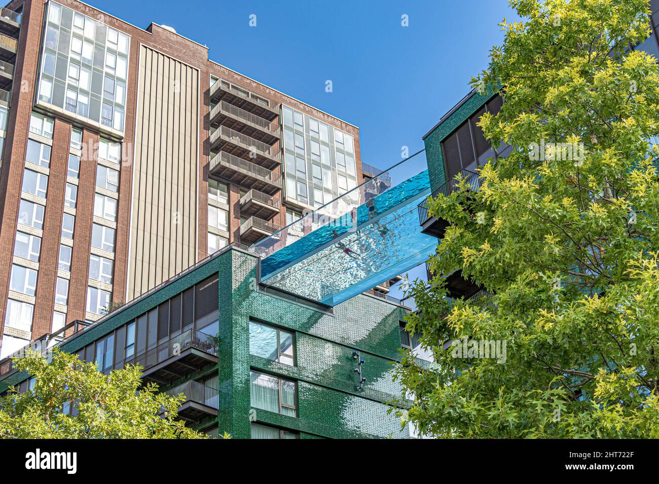 Menschen schwimmen im Sky Pool, der sich zwischen zwei luxuriösen Apartmentgebäuden in Embassy Gardens in Nine Elms, London, Großbritannien, erstreckt Stockfoto