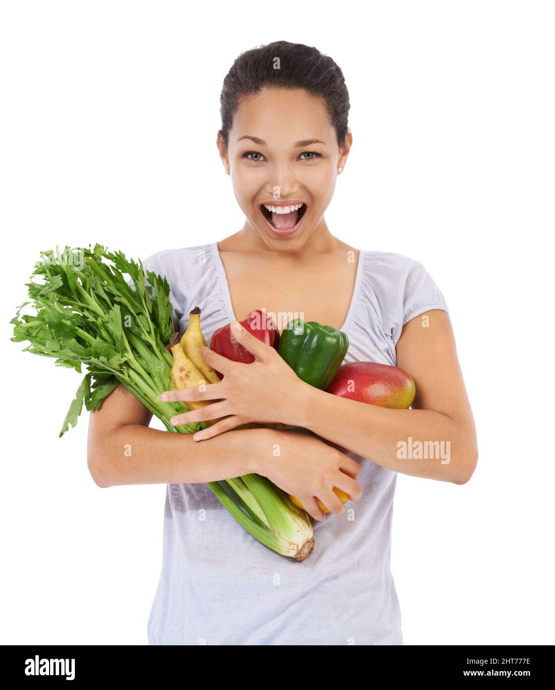 Diese Gemüse sind einfach so frisch. Junge Frau lächelt, während sie eine Armvoll frisches Gemüse hält - isoliert. Stockfoto