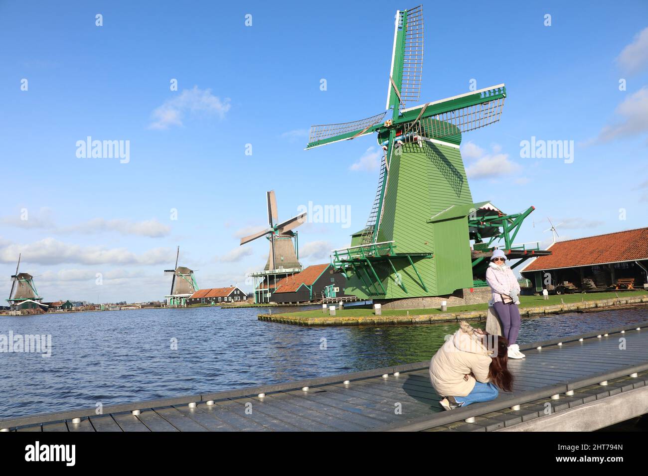 Touristen fotografieren vor den Windmühlen Zaanse Schans, Zaandam, Niederlande, Januar 2022 Stockfoto