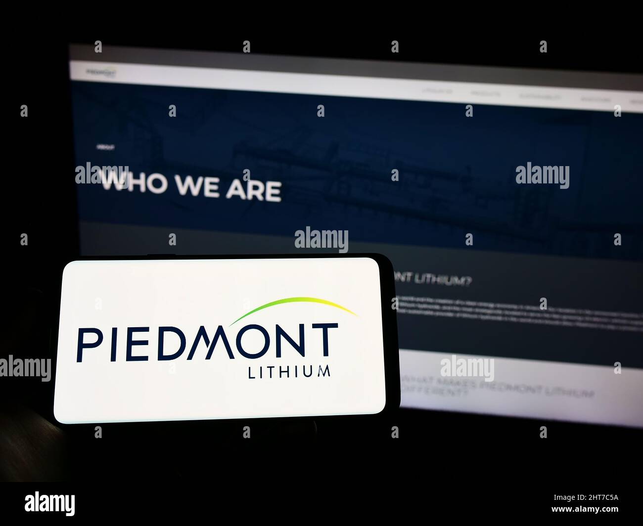 Person mit Mobiltelefon und Logo des US-Bergbauunternehmens Piedmont Lithium Inc. Auf dem Bildschirm vor der Business-Webseite. Konzentrieren Sie sich auf die Telefonanzeige. Stockfoto