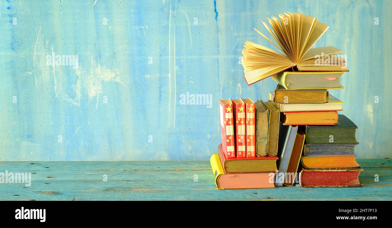Öffnen Sie das Buch auf einem Stapel alter Hardback-Bücher. Zurück zur Schule, Bildung, Lesen. Speicherplatz kopieren Stockfoto