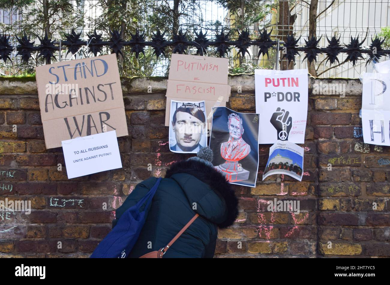 London, Großbritannien. 27.. Februar 2022. Ein Protestler schreibt eine Anti-Putin-Botschaft an die Wand. Demonstranten versammelten sich vor der russischen Botschaft aus Protest gegen die Invasion der Ukraine. In den letzten Tagen bedeckten Demonstranten die Mauer und den Eingang der Botschaft mit Schilder und Kreidebotschaften gegen Putin, gegen den Krieg und gegen die Ukraine. Kredit: Vuk Valcic/Alamy Live Nachrichten Stockfoto