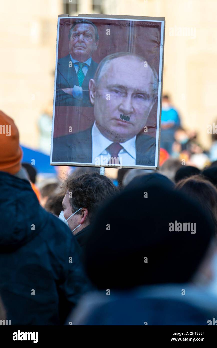 Dresden, Deutschland. 27.. Februar 2022. Ein Mann hält ein Abbild des russischen Präsidenten Putin und des ehemaligen Kanzlers G. Schröder bei einer Demonstration auf dem Neumarkt-Platz gegen den russischen Angriff auf die Ukraine. Nach Angaben der Polizei versammelten sich nach einem Aufruf der Parteien in Dresden mehr als 3000 Personen. Quelle: Daniel Schäfer/dpa-Zentralbild/dpa/Alamy Live News Stockfoto