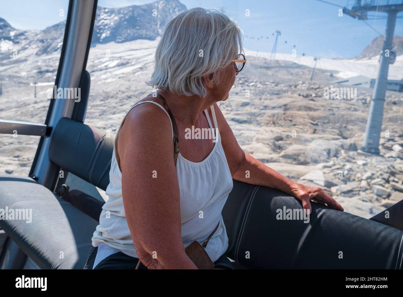 Ältere Frauen blicken von innen in eine Seilbahn in die alpen, Bild vom kitzsteinhorn Gebiet Österreich. Fokus auf Vordergrund. Stockfoto