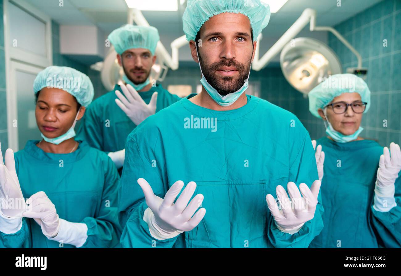 Erfolgreiches Team von Chirurgen stehen im Operationssaal, bereit, an einem Patienten zu arbeiten Stockfoto