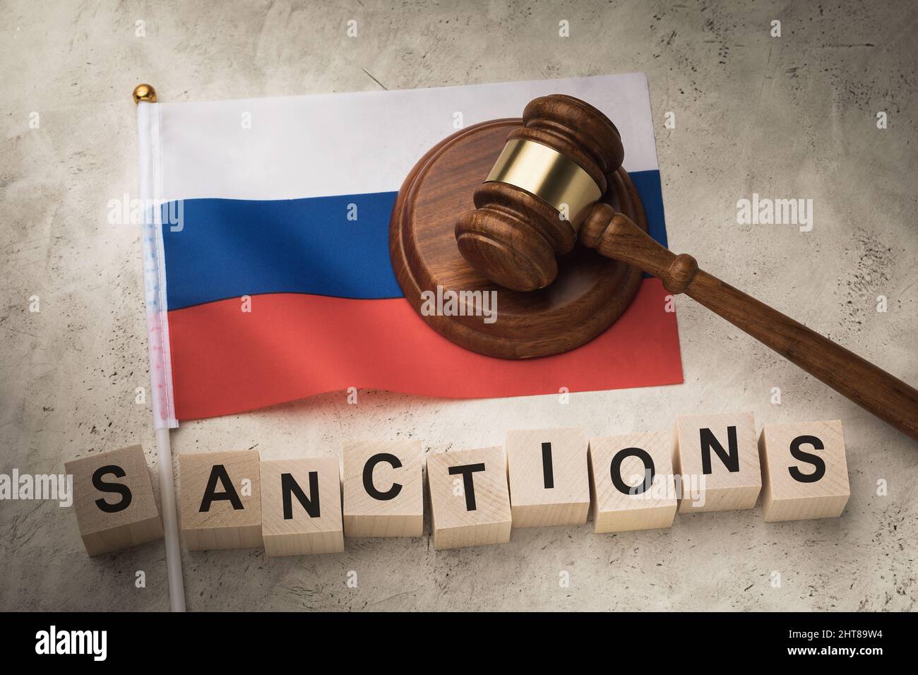 Richter Gavel, Holzwürfel mit Text und Flagge Russlands auf abstraktem Hintergrund, ein Konzept zum Thema Sanktionen in Russland Stockfoto