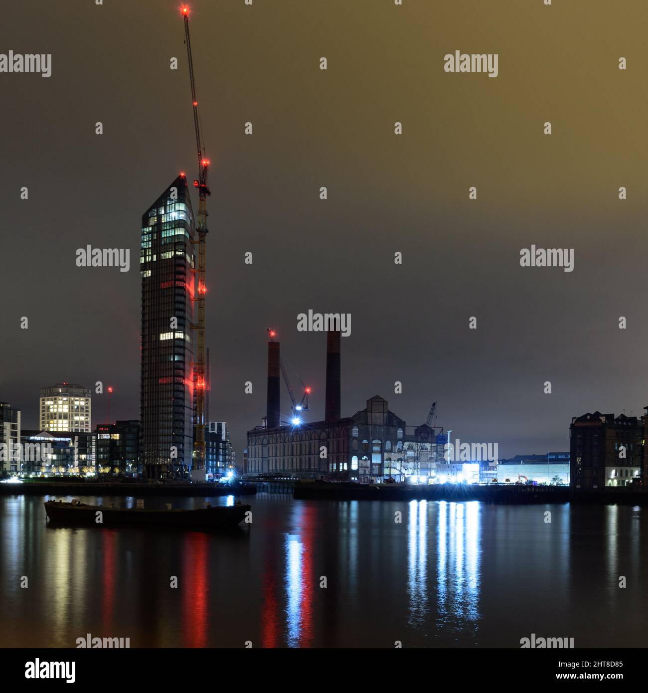 London, England, Großbritannien - 28 Dezember, 2018: Turmdrehkrane in der Nacht beleuchtet sind neben neuen Apartment Gebäude errichten und das verlassene Lots Road Power Station i Stockfoto