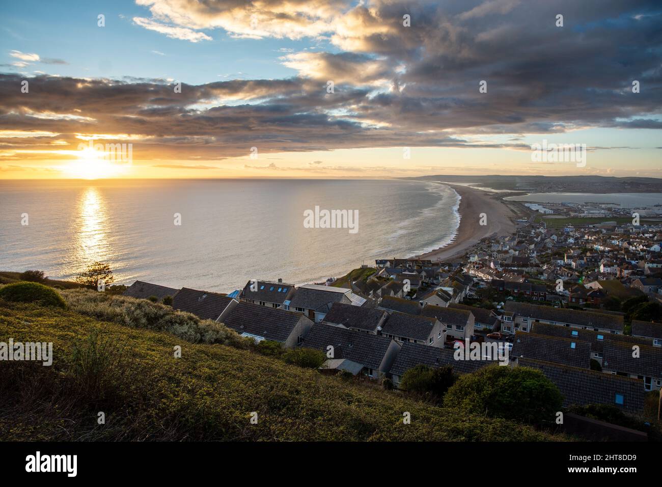 Die Sonne geht über Lyme Bay und Chesil Beach an der Jurassic Coast von Dorset unter. Stockfoto
