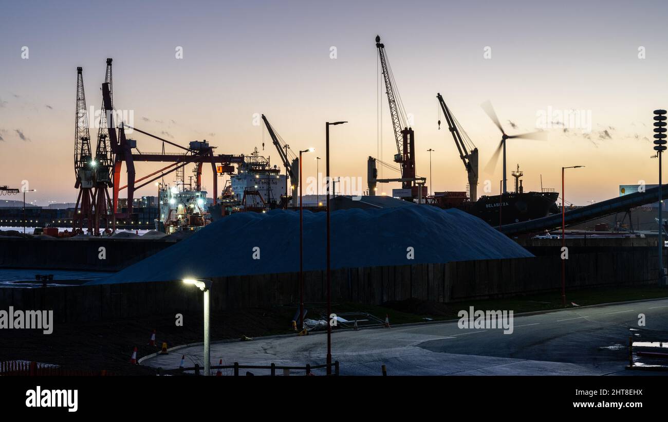 Die Sonne geht über den Avonmouth Docks unter, während große Massenfrachtschiffe in Bristol entladen werden. Stockfoto