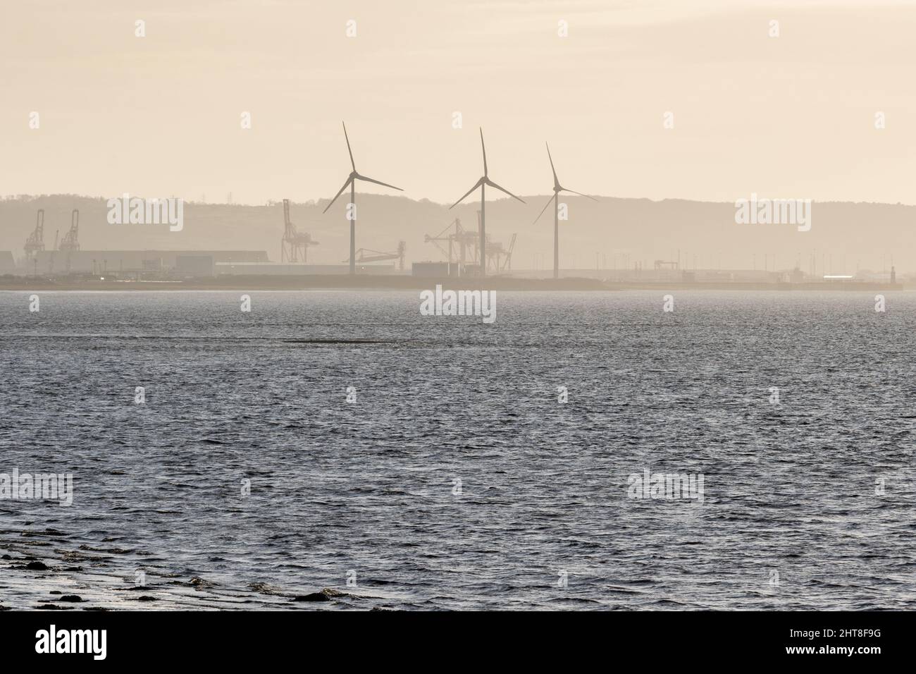 Krane und Windkraftanlagen steigen aus der industriellen Landschaft der Avonmouth Docks am englischen Bristol Channel. Stockfoto